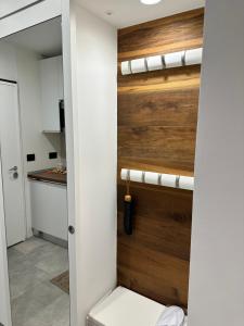 a bathroom with a toilet and a wooden wall at Appartamento Alpino Cles in Cles