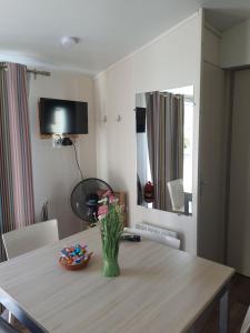 a dining room table with a vase of flowers on it at Mobil Home Ohana Camping du Ried in Boofzheim
