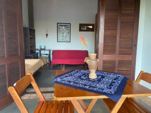 a living room with a table and a red couch at Casa nos Algodoes, imersa na natureza in Marau