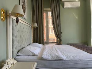 a bedroom with a large bed with a window at Royal City Hotel in Kyiv