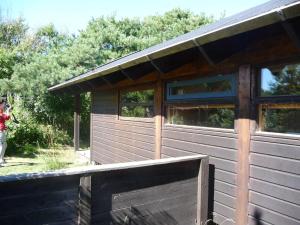 drewniany domek z oknami na boku w obiekcie Cozy Cottage Close To The Beach w mieście Liseleje