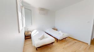 Habitación con 2 sillas blancas y ventana en La Petite Vague, en Saint Gilles Croix de vie