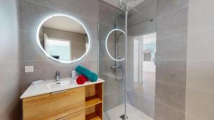 Un baño con ducha, lavabo y espejo. en La Petite Vague, en Saint Gilles Croix de vie 19 fotos más