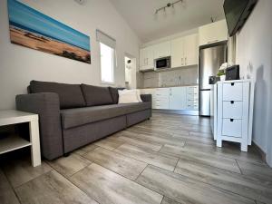 a living room with a couch and a kitchen at Colorado Golf by Infinity Summer in Maspalomas
