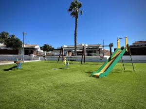 a park with a playground with a slide and a palm tree at Colorado Golf by Infinity Summer in Maspalomas