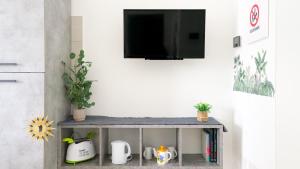 a living room with a table with a tv on a wall at Brisa Blanca in Alghero