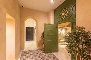 a green door in a hallway with a plant at Aladro Apartamentos by Valcambre in Jerez de la Frontera +88 photos