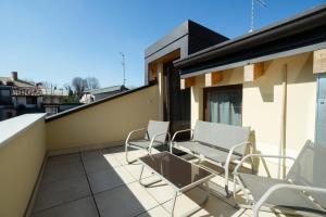 a balcony with chairs and a table on a building at Loft Roby in Peschiera del Garda +59 photos