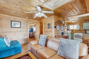 a living room with a couch and a ceiling fan at Grand Lake Cabin Escape in Grand Lake