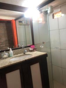 a bathroom with a sink and a mirror and a shower at Rústica Chapas P in Lençóis