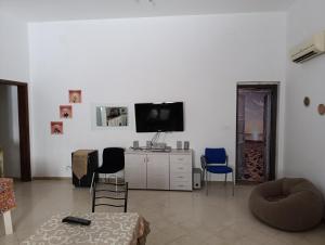 a living room with two chairs and a tv at casa colombo in Balestrate