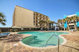 a swimming pool in front of a building at Steps to Sand Myrtle Beach Gem with Oceanfront Pool in Myrtle Beach