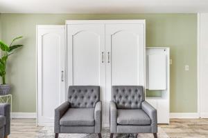 two chairs in a living room with green walls at Steps to Sand Myrtle Beach Gem with Oceanfront Pool in Myrtle Beach