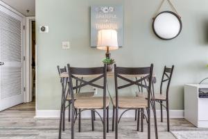 a dining room table with four chairs and a mirror at Steps to Sand Myrtle Beach Gem with Oceanfront Pool in Myrtle Beach