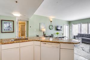 a kitchen with a sink and a living room at Steps to Sand Myrtle Beach Gem with Oceanfront Pool in Myrtle Beach