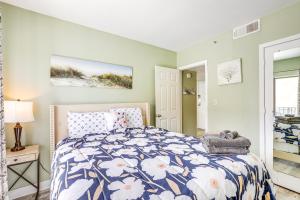 a bedroom with a bed with a blue and white comforter at Steps to Sand Myrtle Beach Gem with Oceanfront Pool in Myrtle Beach