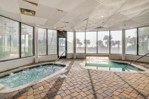 a large room with a swimming pool with windows at Steps to Sand Myrtle Beach Gem with Oceanfront Pool in Myrtle Beach