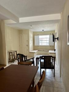 a dining room with tables and chairs and a window at Recanto aconchego in Santa Cruz