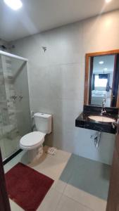 a bathroom with a toilet and a sink and a shower at Hotel Ubuzios in Anchieta +25 photos
