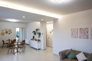 a living room and dining room with a table and chairs at Villa Kora Suites&Pool in San Leone