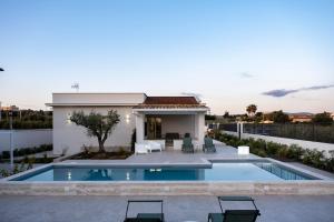 a villa with a swimming pool and a house at Villa Kora Suites&Pool in San Leone