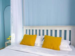 a bed with yellow pillows in a blue bedroom at Keisha Luxury Furnished Apartment Bukoto in Kampala