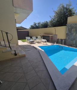 a swimming pool in a yard with chairs and a table at exclusive use swimming pool available from June to September in Cagliari