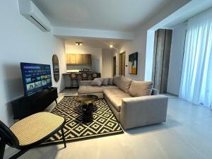 a living room with a couch and a flat screen tv at 204 Lux Suites Level2 Tower 206 in Nicosia