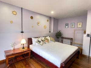 um quarto com uma cama e uma mesa com um abajur em The Memory Hostel em Trat