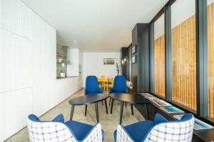 a dining room with blue chairs and a table at Engenho Hostel in Lajes do Pico