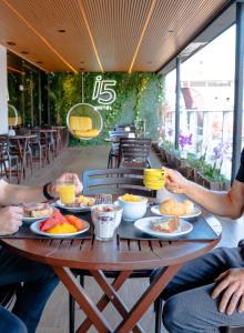 a group of people sitting around a table with food at i5 Hotel - Taguatinga in Taguatinga