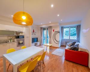 a kitchen and living room with a white table and yellow chairs at San Paolo Apartment in Pisa +17 photos