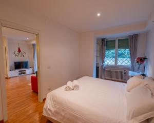 a bedroom with a white bed with two shoes on it at San Paolo Apartment in Pisa