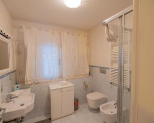 a white bathroom with a sink and a toilet at San Paolo Apartment in Pisa