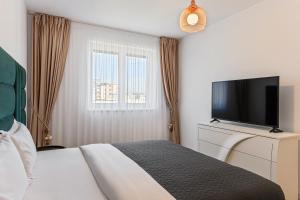 Un dormitorio con una cama y un televisor de pantalla plana. en KOA - Twin Tower, en Brasov