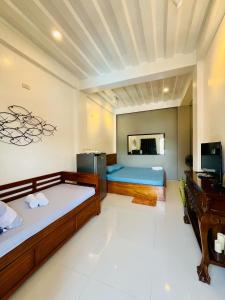 um quarto com duas camas e uma secretária em FN Lodge - town proper em Palompon