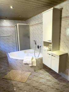 a bathroom with a tub and a shower at Apartment Rosengarten - Rosenheim Apartments in Tires