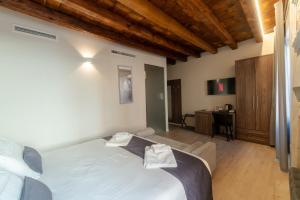 Un dormitorio con una cama grande y un escritorio. en La Casa in Paese, en Peschiera del Garda