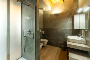 Un baño con ducha, lavabo e inodoro. en La Casa in Paese, en Peschiera del Garda