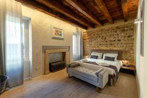 Un dormitorio con una cama y una pared de piedra. en La Casa in Paese, en Peschiera del Garda