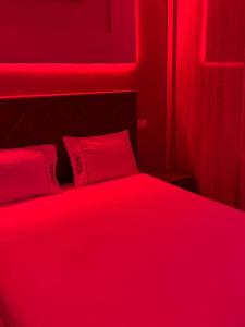 une chambre rouge avec un lit avec deux oreillers rouges dans l'établissement Dar location luxury, à Meknès