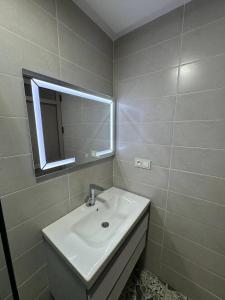une salle de bain avec un lavabo et un miroir dans l'établissement Dar location luxury, à Meknès