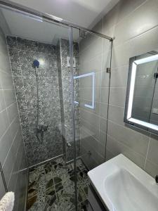une salle de bain avec douche et lavabo dans l'établissement Dar location luxury, à Meknès