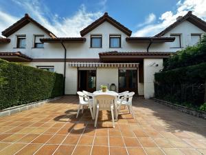 a patio with a table and chairs in front of a house at Villa de Pedrena - 32801 in Pedreña