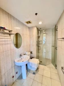a bathroom with a sink and a shower and a toilet at Metro Luxe Stay Near DOJ Embassy and St Lukes in Manila