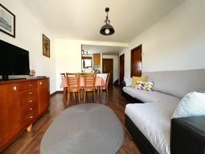 a living room with a couch and a table with chairs at Villa de Pedrena - 32801 in Pedreña