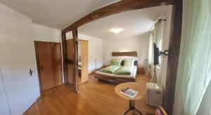 a bedroom with a bed and a table in a room at Gasthaus Korneli in Sankt Aldegund