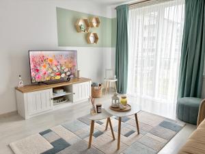 a living room with a flat screen tv on a cabinet at Wanderlust Home Mint, Rasnov Apt for 4, Wifi and Free Parking in Râşnov