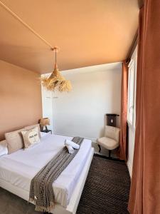 a bedroom with a bed and a chair at La Pilate, avec vue sur les toits de Rennes in Saint-Jacques-de-la-Lande