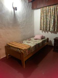 a small bed in a room with a window at Guille y Ely in Valeria del Mar